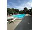 Inviting community pool with lounge chairs, mature trees, and a serene atmosphere on a sunny day at 2103 Ranch Dr, Westminster, CO 80234