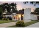 Charming single-story home with a white brick exterior, dark roof, manicured lawn and mature trees at 2941 Oneida St, Denver, CO 80207
