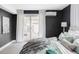 Well-lit main bedroom featuring plush bedding, dark accent wall, backyard access, and comfortable carpeting at 2941 Oneida St, Denver, CO 80207