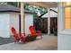 Covered patio with outdoor seating and small tables, view of the fenced yard and detached garage at 2941 Oneida St, Denver, CO 80207