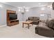 Cozy basement with a leather sofa, plush armchair, and wooden TV stand in front of gray walls and plush carpeting at 2741 Java Ct, Denver, CO 80211