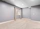 Basement space with gray walls, a window with curtains, neutral carpeting, and white baseboards at 2741 Java Ct, Denver, CO 80211