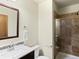 Bathroom featuring a sleek vanity, toilet, and glass-enclosed shower with decorative stone accents and neutral tile at 2741 Java Ct, Denver, CO 80211