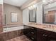 Bathroom features a soaking tub, double vanity with granite counters, and dark wood cabinets at 2741 Java Ct, Denver, CO 80211