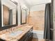 Bathroom with dual sinks, granite countertop, shower with stone accents, and large mirrors at 2741 Java Ct, Denver, CO 80211
