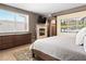 Well-lit bedroom featuring a fireplace, large window, and comfortable furnishings at 2741 Java Ct, Denver, CO 80211