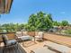 Open-air deck featuring outdoor seating, a coffee table, lounge chairs, and green treetop views beyond the railing at 2741 Java Ct, Denver, CO 80211