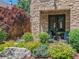 Charming home with stone facade, black trim, and lush garden area with chairs at 2741 Java Ct, Denver, CO 80211