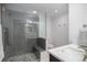 Modern bathroom with a walk-in shower, gray tile, and a single sink vanity at 7696 S Hudson Way, Centennial, CO 80122