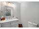 Clean, well-lit bathroom featuring grey vanity and sink with modern fixtures and toilet at 7696 S Hudson Way, Centennial, CO 80122