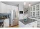 Bright kitchen featuring a stainless refrigerator, white cabinets, and an eat-in island at 7696 S Hudson Way, Centennial, CO 80122
