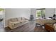 Inviting living room features wood-look floors, a comfortable sofa, and a bright window with scenic outdoor views at 7696 S Hudson Way, Centennial, CO 80122