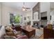 Inviting living room features a stone fireplace, large windows, and comfortable leather seating at 7696 S Hudson Way, Centennial, CO 80122