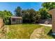 Fenced backyard featuring a storage shed, mature trees, lush lawn, and a barbecue grill ready for summer gatherings at 1371 W 133Rd Way, Denver, CO 80234