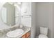 Bright bathroom featuring a granite countertop, oval mirror, and white toilet at 1371 W 133Rd Way, Denver, CO 80234