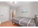 This bedroom features a closet, a door to the bathroom, a ceiling light and warm-colored wood floors at 1371 W 133Rd Way, Denver, CO 80234