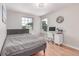 Bedroom with hardwood floors, a gray bed, a desk, and two windows at 1371 W 133Rd Way, Denver, CO 80234
