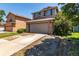 Two-story home with an attached garage, a driveway, and green lawn at 1371 W 133Rd Way, Denver, CO 80234