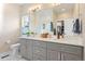 Bright bathroom with dual sink vanity, white countertops, and a large mirror at 3103 S Cherokee St, Englewood, CO 80110