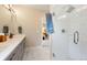 Bathroom featuring a glass-enclosed shower with white tiled walls and a dual sink vanity at 3103 S Cherokee St, Englewood, CO 80110