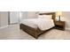 Cozy bedroom with wood bed frame, neutral bedding, and convenient bedside table at 3103 S Cherokee St, Englewood, CO 80110