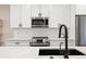 Close up of the kitchen showing white cabinets, stainless steel appliances, and a white backsplash at 3103 S Cherokee St, Englewood, CO 80110