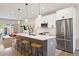 Modern kitchen boasts stainless appliances, white cabinets, island with seating, and stylish pendant lighting at 3103 S Cherokee St, Englewood, CO 80110