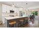 Modern kitchen with white cabinets, stainless steel appliances, and a large island with seating at 3103 S Cherokee St, Englewood, CO 80110