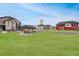 View of the neighborhood with green space, a gazebo, and colorful homes under a clear blue sky at 17851 E 103Rd Ave, Commerce City, CO 80022