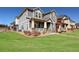 Charming gray two-story home with stone accents, covered porch, and well-manicured lawn on a sunny day at 17851 E 103Rd Ave, Commerce City, CO 80022