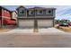 Two-story gray house with two garage doors and well manicured landscaping at 17851 E 103Rd Ave, Commerce City, CO 80022