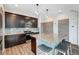 Modern kitchen with dark cabinetry, granite countertops, and a stylish center island with seating at 17851 E 103Rd Ave, Commerce City, CO 80022