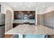Contemporary kitchen with granite island, dark cabinetry, and modern stainless steel appliances at 17851 E 103Rd Ave, Commerce City, CO 80022