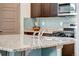 Close-up of a granite kitchen island featuring a stainless steel sink and faucet at 17851 E 103Rd Ave, Commerce City, CO 80022
