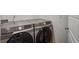 Modern side-by-side Samsung washer and dryer in neutral laundry room at 17851 E 103Rd Ave, Commerce City, CO 80022