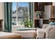 Cozy living room corner with view of a window with house view, plant, ottoman, and the kitchen in the background at 17851 E 103Rd Ave, Commerce City, CO 80022
