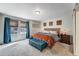 Bright main bedroom with carpet, large window with blinds and curtains, and a comfortable seating area at foot of bed at 17851 E 103Rd Ave, Commerce City, CO 80022
