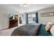 Main bedroom with large window with blinds and curtains, dresser, and television for optimal relaxation at 17851 E 103Rd Ave, Commerce City, CO 80022