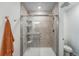 Standing shower with tile surround, glass doors, and shower head, next to a toilet in a bathroom at 17851 E 103Rd Ave, Commerce City, CO 80022