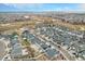 Scenic aerial view of a neighborhood with varied home styles, green spaces, and a golf course in the background at 4981 Liverpool St, Denver, CO 80249