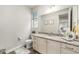 Well-lit half bathroom featuring granite countertops and white cabinets at 4981 Liverpool St, Denver, CO 80249