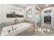 Luxurious bathroom with a soaking tub, a separate walk-in shower, and mountain art at 4981 Liverpool St, Denver, CO 80249