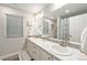 Bright bathroom featuring double sinks with marble countertops and a large mirror at 4981 Liverpool St, Denver, CO 80249