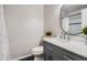 Modern bathroom with gray vanity, marble countertop, decorative mirror, and black and white tile at 11029 Grouse Ct, Parker, CO 80134