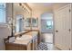 Well-lit bathroom with double sinks, wood cabinets, and a view of the bedroom at 11029 Grouse Ct, Parker, CO 80134