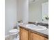Well-lit half bathroom featuring a modern sink, faucet, mirror, and toilet at 11029 Grouse Ct, Parker, CO 80134