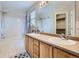 Well-lit bathroom with double sinks, wood cabinets, large mirror, and shower-tub combo at 11029 Grouse Ct, Parker, CO 80134