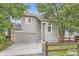 Charming home featuring a two-car garage, light colored siding, and mature trees at 11029 Grouse Ct, Parker, CO 80134
