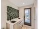 Stylish bar area with a sleek sink, wood cabinets, and a unique living wall, leading to a private balcony at 2323 S High St, Denver, CO 80210