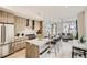 Modern kitchen featuring light wood cabinets, stainless steel appliances, and a spacious island with bar seating at 2323 S High St, Denver, CO 80210
